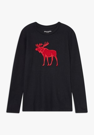 Chemise noire à manches longues avec col rond présentant un grand motif élan rouge sur le devant et une étiquette Abercrombie à l’intérieur du col.