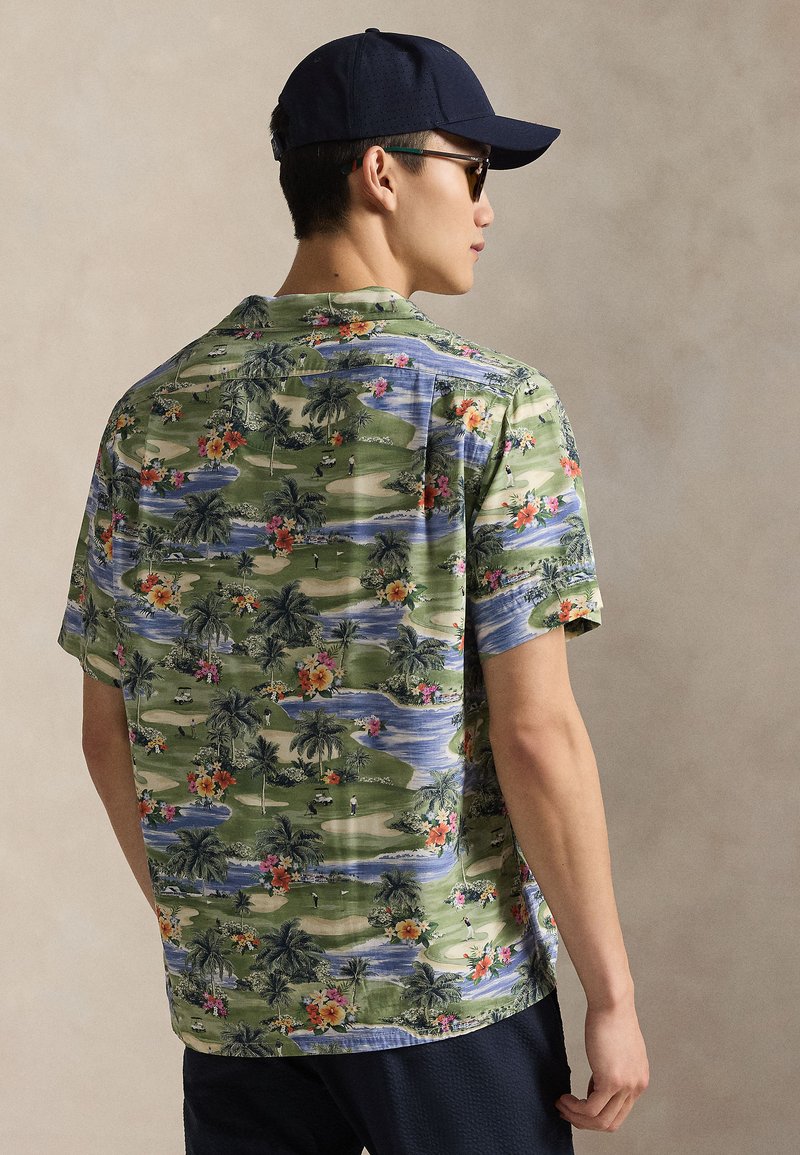 Short-sleeve shirt in green fabric featuring a tropical floral and landscape print, with a camp collar and relaxed fit.