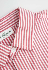 Koszula w czerwono-białe paski z kołnierzykiem, wykonana z bawełny, posiada zapięcie na guziki oraz metkę z informacjami o marce.