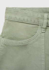 Svijetlozeleni pamuk denim tkanina s džepom, glatke teksture i kontrastnim šavovima na pojasu i rubovima.