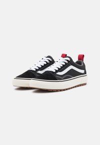 Sorte mokasiner i semsket skinn med hvite snørebånd, med en hvit stripe på siden og en rød hæltab. Tykk gummisåle med teksturert grep.