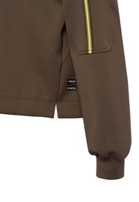 Bruine sportjas met perforaties, gele streep details en een Marc Cain Sports label bij de zoom.