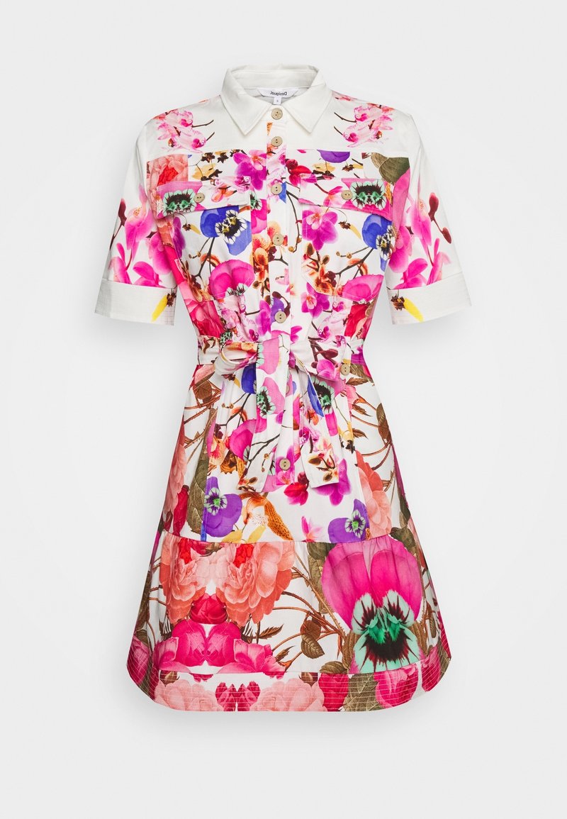 Robe chemise fleurie blanche avec des fleurs roses, violettes et bleues. Dotée de manches courtes, d'un col, de boutons et d'un détail de taille nouée.