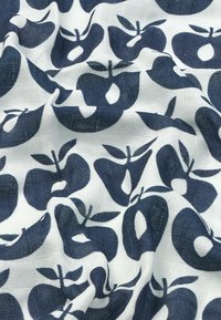 Katoenen stof met een herhalend patroon van donkerblauwe appels op een witte achtergrond, met zichtbare textuur en weefdetails.