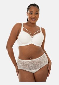 Weißer BH mit Spitzenverzierungen, gepolsterten Cups und verstellbaren Trägern, kombiniert mit weißen Slips mit Spitzenakzenten. Glatte Textur, feminines Design.