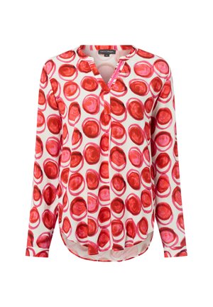 Langärmlige Bluse mit rundem Ausschnitt, weißem Grund und rotem kreisförmigen Muster darauf.