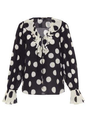 Blouse à pois noir et blanc avec col à volants, décolleté avec nœud et manches évasées. Fabriquée en tissu léger avec une texture douce.