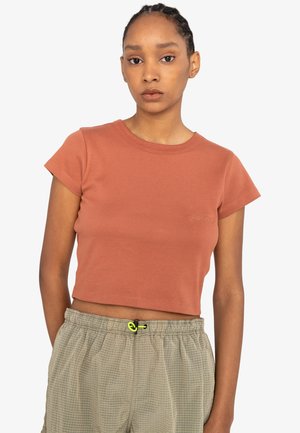 Rust-colored cropped t-shirt with short sleeves and a round neckline. Made of ribbed material, featuring subtle logo embroidery on the chest.