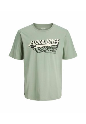 T-shirt en coton vert clair à manches courtes. Présente un texte graphique en noir et blanc audacieux "JACK&JONES DENIM GOODS" sur le devant.
