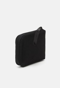 Cartera negra con cremallera hecha de tela texturizada. Forma rectangular compacta con un tirador de cremallera visible. Diseño simple y minimalista.
