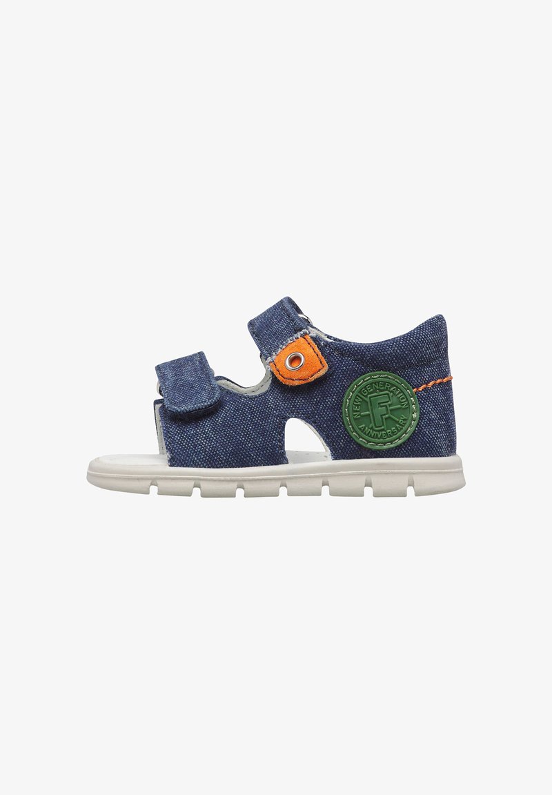 Sandale bleue pour tout-petit avec semelle blanche, deux bandes Velcro ajustables, coutures orange et un patch logo circulaire vert.