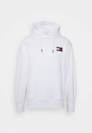 Weißer Kapuzenpullover mit vorderer Kängurutasche, verstellbarer Kapuze mit Kordelzug und kleinem rot-weiß-blauem Tommy Jeans-Logo-Patch auf der oberen Brust.