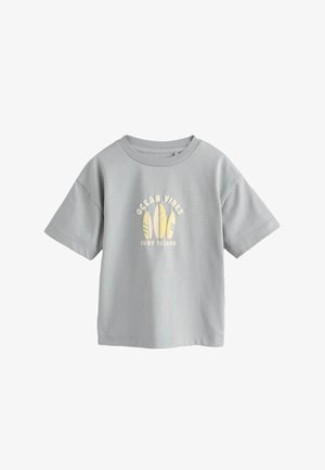 Light grey short-sleeve T-shirt with crew neck, featuring three yellow surfboard illustrations and text "OCEAN VIBES SURF ISLAND" on front.