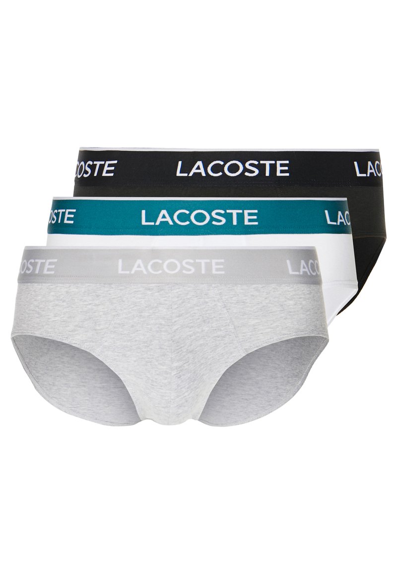 Tres pares de calzoncillos de hombre en gris, negro y azul verdoso, con cinturillas elásticas contrastantes que llevan el logo "LACOSTE" en blanco. Material suave de mezcla de algodón.