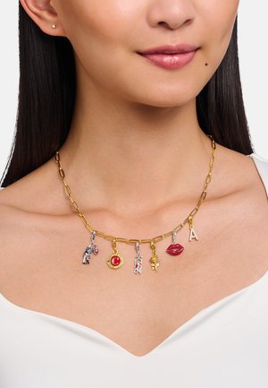 Goldfarbene Kettenhalskette mit verschiedenen bunten Anhängern: rote Lippen, eine Rose, ein „C“ und eine Figur, mit abwechselnden silberfarbenen Gliedern.