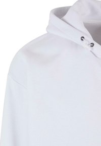 Felpa bianca con cappuccio regolabile, realizzata in cotone, con una finitura leggermente testurizzata, caratterizzata da un colletto arrotondato e cuciture sulle spalle.