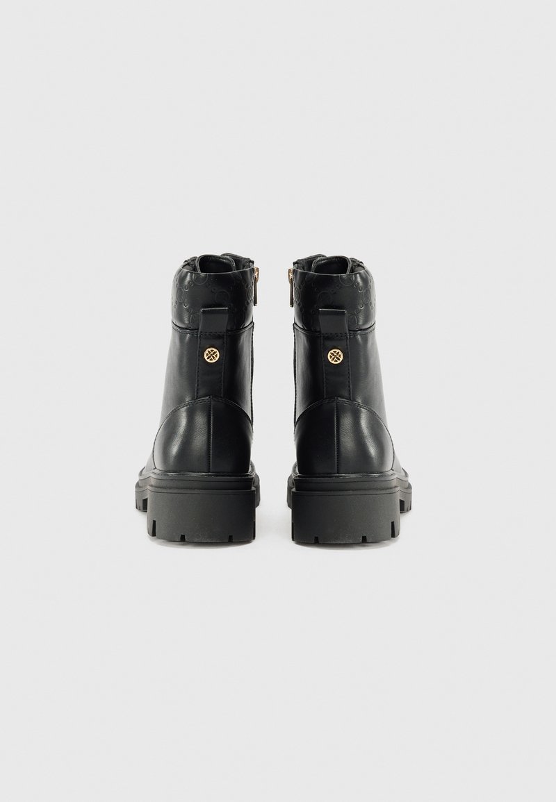 Stivali alla caviglia in pelle nera con design texturizzato, suola in gomma spessa, dettagli in metallo dorato e zip posteriore per una facile calzata.