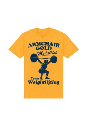 Złotawo-żółta koszulka z niebieskim graficznym napisem "Armchair Gold Medallist" oraz sylwetką sztangisty, z wyraźnym zużyciem.