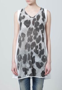 Top senza maniche con scollo a V, caratterizzato da un design a stampa leopardata in bianco e nero e grigio, con un pannello laterale bianco, realizzato in un tessuto leggero e con una texture.