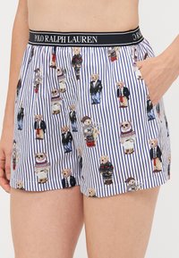 Cotton boxers with a navy striped pattern. Features colorful bear illustrations in various outfits. Elastic waistband with logo.