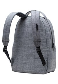 Mochila de tela gris con forma redondeada, correas acolchadas ajustables, cierre de cremallera, bolsillo frontal y un sutil patrón de textura.