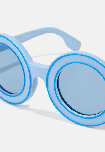 Occhiali da sole rotondi in plastica blu chiaro con accenti blu scuro. Le lenti sono colorate di blu con montature circolari abbinate, caratterizzate da un design elegante.