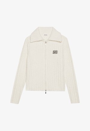 Witte ritsjack met een geribbeld textuur, grote kraag en zwarte patchdetails. Voorzien van een rits in het midden en lange mouwen.