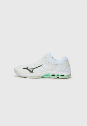 White athletic shoe with a mesh upper, gray accents, and a green outsole. Features a prominent black logo and textured patterns on the side.