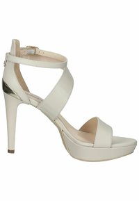 Sandal con tacco alto bianco, dotato di una tomaia in pelle liscia, cinturini incrociati alla caviglia, punta aperta e un accento metallico sul tacco.