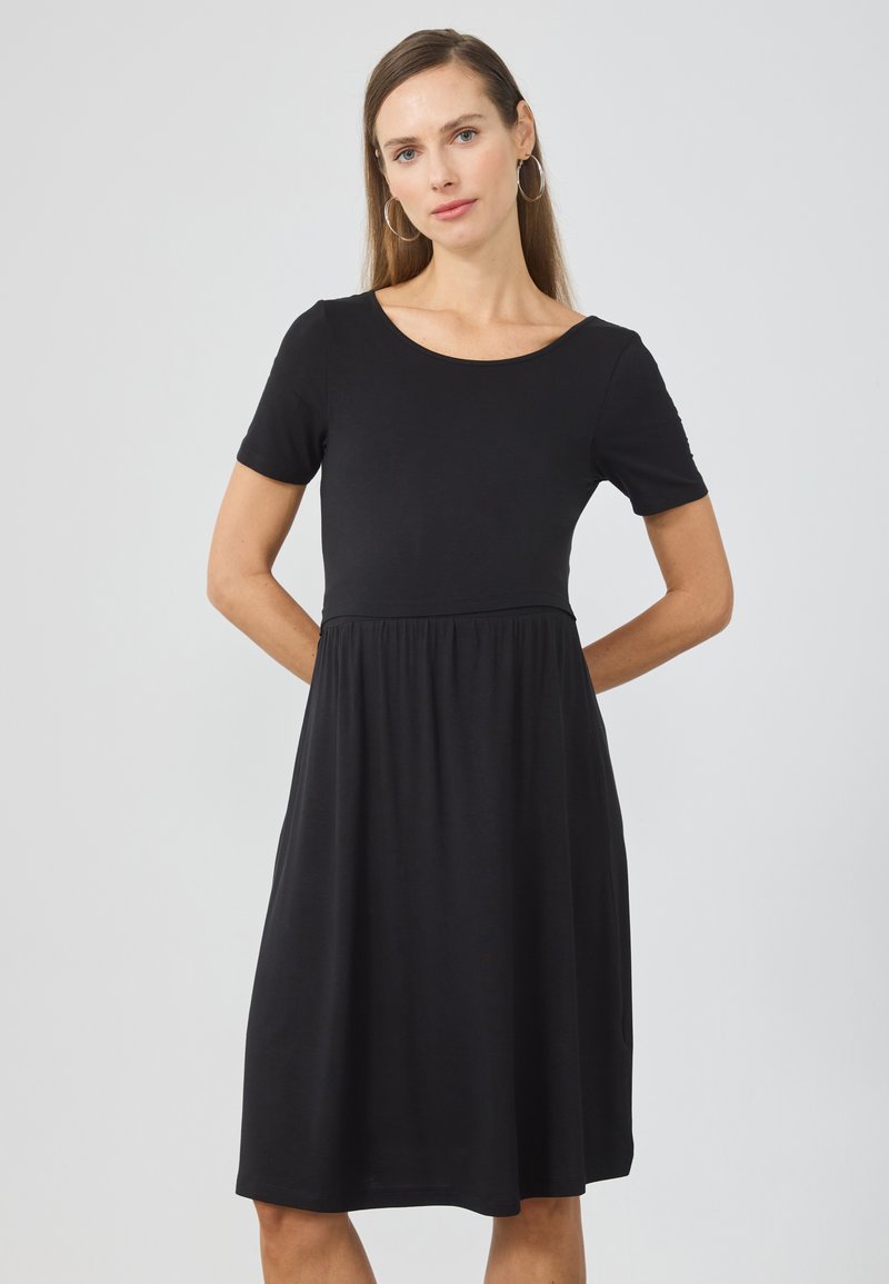 Svart kortermet kjole laget av et mykt stoff, med en tettsittende bodice og en utsvingt skjørt, med rund hals og uten mønstre.