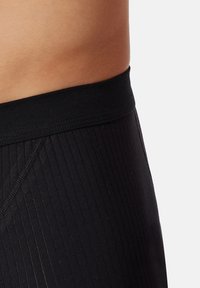 Boxer shorts neri con vita a coste e tessuto, caratterizzati da linee verticali, una consistenza morbida e una vestibilità aderente in vita.