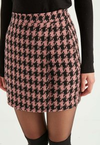 Rosen- und schwarze Hahnentrittmuster-Rock mit taillierter Passform, strukturierter Stoff und seitlichen Taschen. Oberhalb des Knies geschnitten.