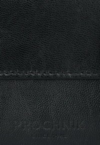 Czarny skórzany portfel o fakturowanym wykończeniu, z przeszywanymi detalami i wytłoczonym logo. Kompaktowy prostokątny kształt.