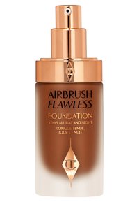 Brown glass foundation bottle with a gold pump and cap. Label features black text on a gradient background, detailing product benefits and brand logo.