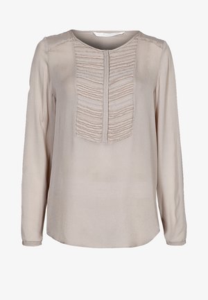 Béžová halenka s dlouhým rukávem, s texturovanou volánovou částí uprostřed, kulatým výstřihem a měkkou, hladkou látkou. Zakulacený okraj.