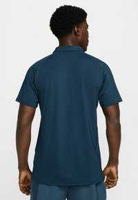 Menns mørkeblå kortermet polo skjorte laget av glatt stoff, med klassisk krage og slim fit design uten synlige mønstre.