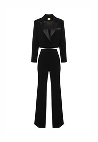 Czarna, krótka marynarka smokingowa z satynowymi klapami, zestawiona z wysokim stanem rozszerzanymi spodniami. Gładka tkanina i przemyślany, strukturalny fason.