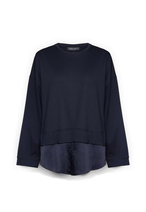 Top azul marino de manga larga con diseño en capas que presenta una parte superior estilo sudadera y un dobladillo de tela sedosa que se extiende por debajo de la cintura.