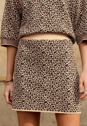 Knit-sweateri ja seelikukomplekt leopardimustriga beežis, mustade ja pruunide laigudega. Rööpsooned käsivarte ja vöökoha juures. Pehme tekstuur.