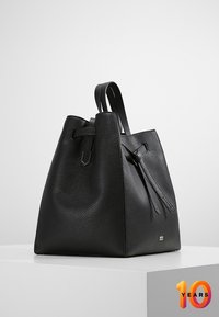 Sort læder bucket taske med tekstureret overflade, tapered form, dobbelt håndtag og et dekorativt snøre detalje. Har subtil branding og robust konstruktion.