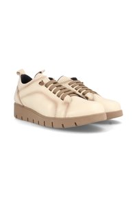 Zapatillas de cuero crema con cordones marrones, suela plana de goma, puntera redondeada y tira en el talón; con costuras mínimas y un diseño texturizado.