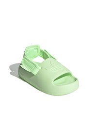 Ljusgröna sandaler gjorda av mjukt, flexibelt material. Öppen tå-design med justerbara remmar och texturerade sulor. Platt konstruktion.