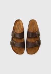 Brune skinnsandaler med to justerbare spenner, semsket innersåler og en avrundet såle. Har preget merkenavn inni.