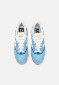 Baskets bleues en mesh et suède, avec des accents blancs, un col rembourré et un logo noir et jaune sur la languette.