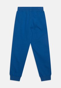 Blauwe sweatpants gemaakt van katoen; heeft een elastische tailleband en opgerolde enkels. Gladde textuur, geen zichtbare patronen of accenten.