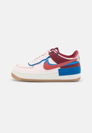 Niskie buty Nike Air Force 1 w kolorze białym, burgundowym, czerwonym i niebieskim z gumową podeszwą, logo Nike Swoosh i wiązanym zamknięciem, widok z boku.