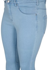 Jeans skinny azul claro, fabricados en denim elástico, con bolsillos frontales, una cremallera clásica y sutiles detalles de costura a lo largo de los laterales.