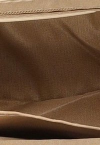 Brun stofindvendig med blød, tekstureret overflade, der har en lysfarvet lynlås og kontrasterende sytråd langs kanterne.