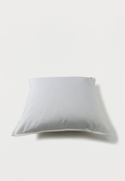 Λευκό ορθογώνιο μαξιλάρι με λεία επιφάνεια υφάσματος σε ανοιχτό φόντο, παρουσιάζοντας ελαφριά σκιά από κάτω.