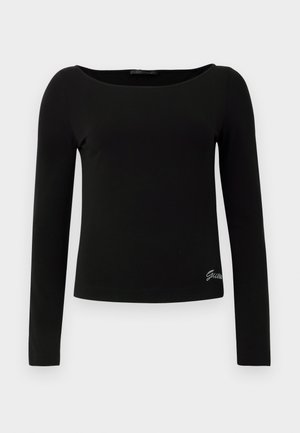 Top ajustado de manga larga negro con escote redondo y pequeño logo de strass "Guess" cerca del dobladillo inferior en el lado derecho.